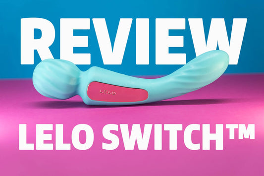 LELO Switch double ended vibrator resting on soft bedding, showing both textured and smooth ends