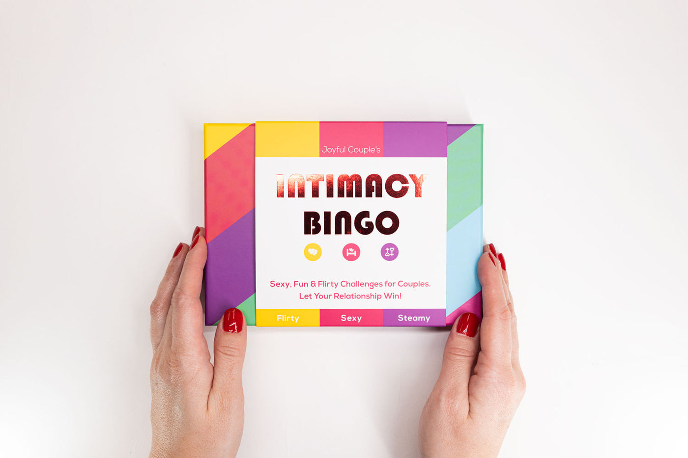 joyful couple's intimacy bingo, box held in hands, on a white background