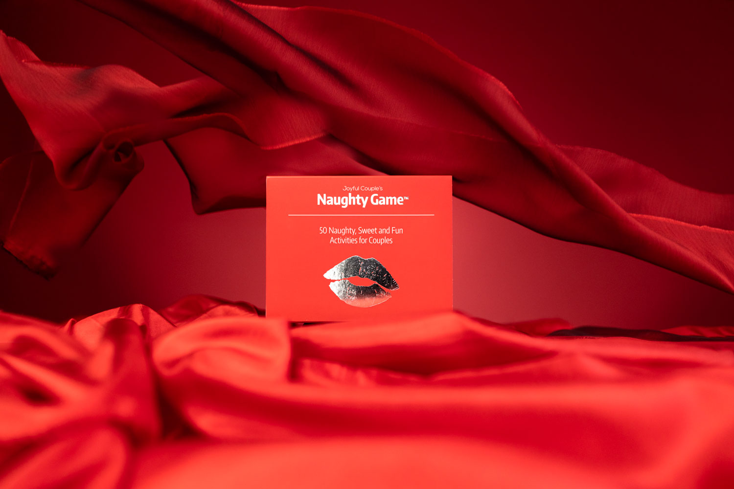the naughty game by joyful couple, on a sensual red satin fabric, in front of red background