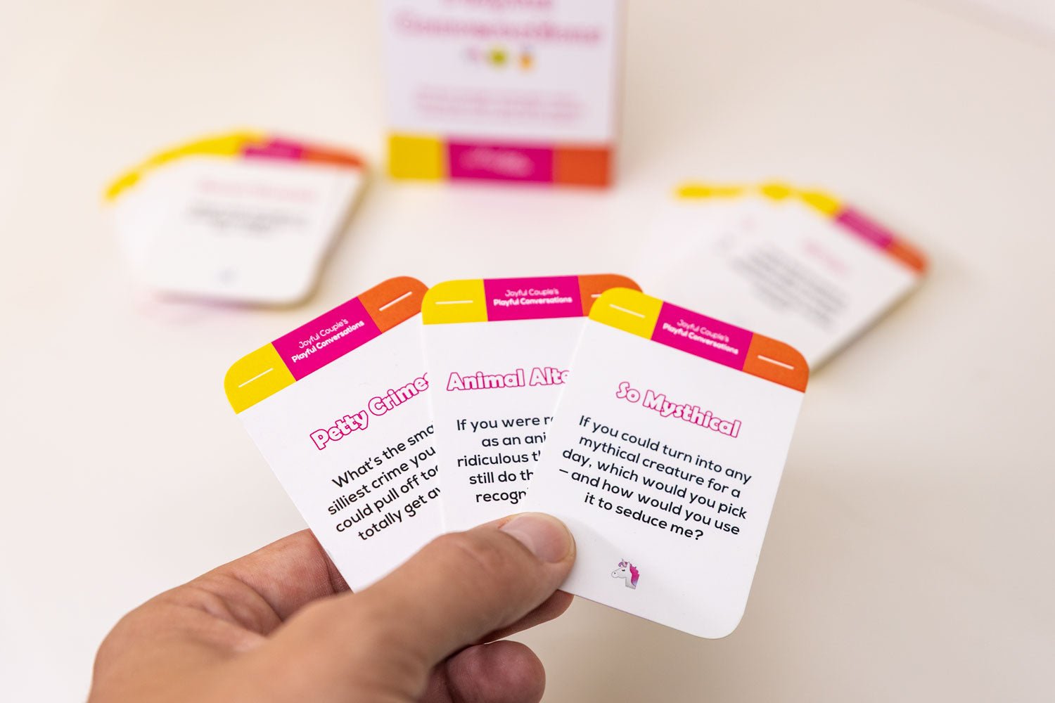 playful conversations by joyful couple, an unserious conversation starter for couples and close friends, some example cards in the hand
